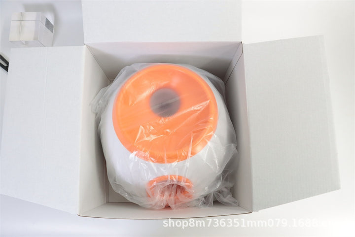An image showing an automatic ball throwing machine in a plastic bag cover inside a box