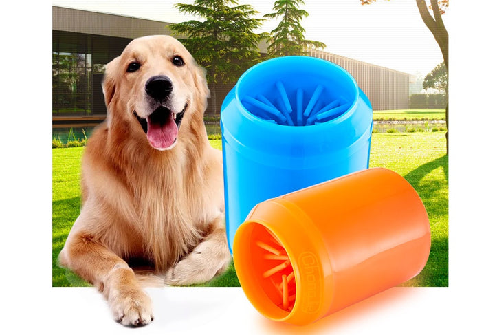 A dog sitting next to a blue and orange automatic foot washing cup designed for pets.