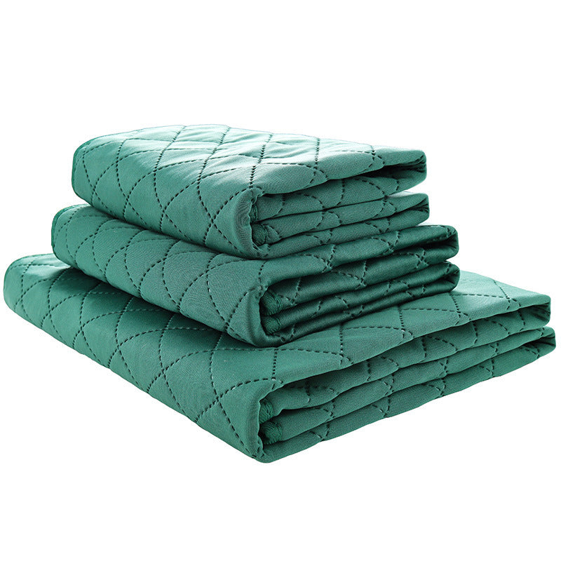 Stack of teal quilted blankets on a white background