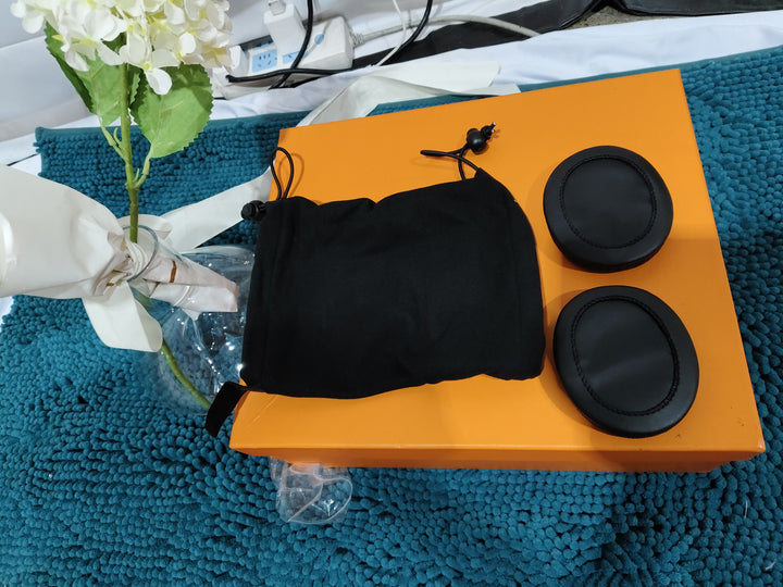 Black Calming Ear Wrap for Dogs on an orange box with a blue textured background