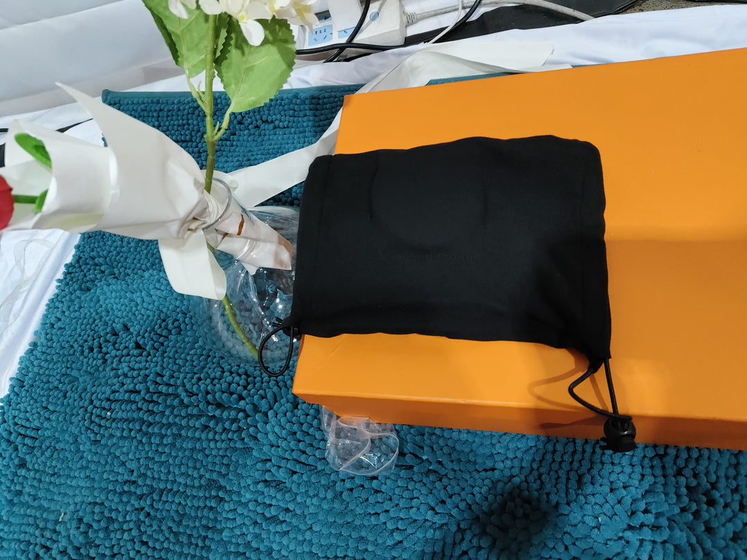 Black Calming Ear Wrap for Dogson an orange surface with a blue textured background