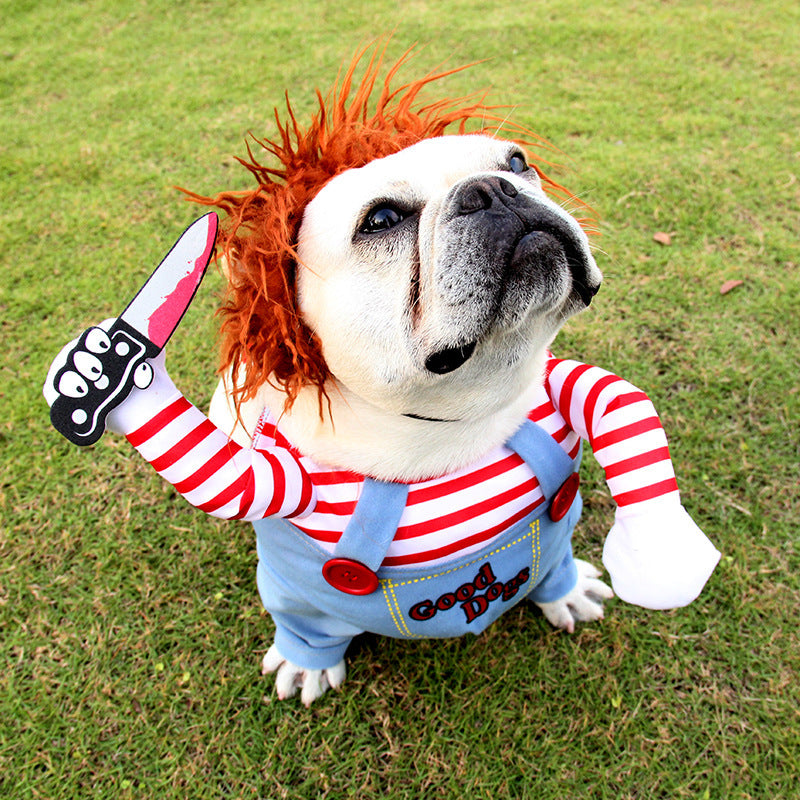 Dog wearing a costume with red hair, striped shirt, and denim overalls on grass.
