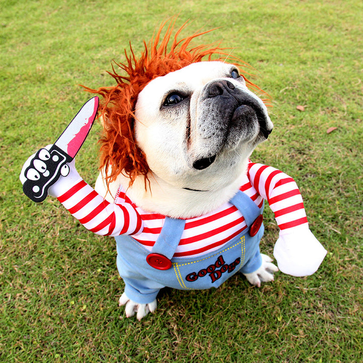 Dog wearing a costume with red hair, striped shirt, and denim overalls on grass.