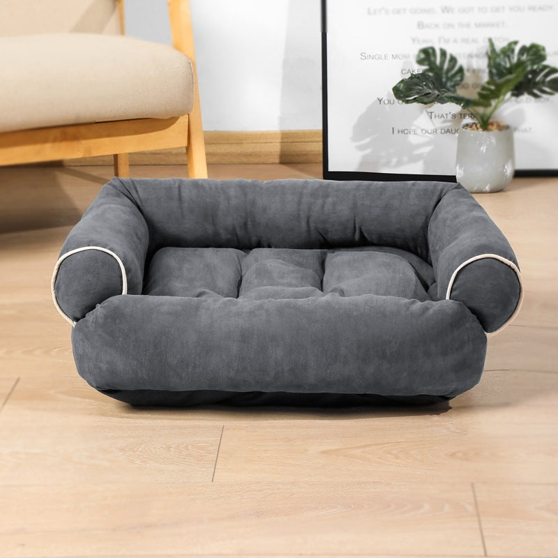 Gray pet bed on a wooden floor with a blurred background