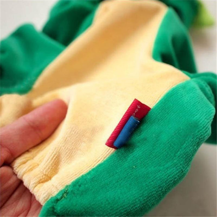 Close-up of a green and yellow fabric with a small red and blue tag, held by a hand. Dinosaur Halloween Pet Costume for Small & Medium Dogs