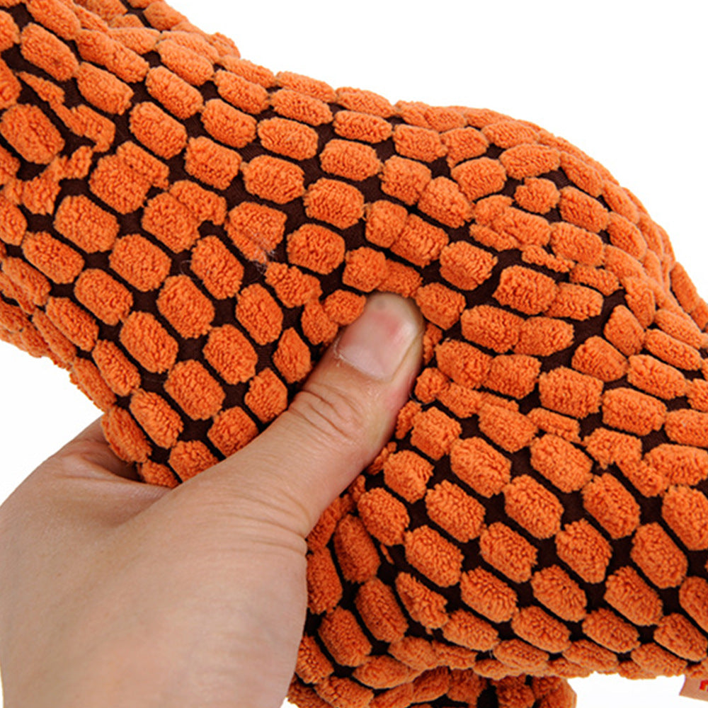 Orange textured dog toy held by a hand against a white background