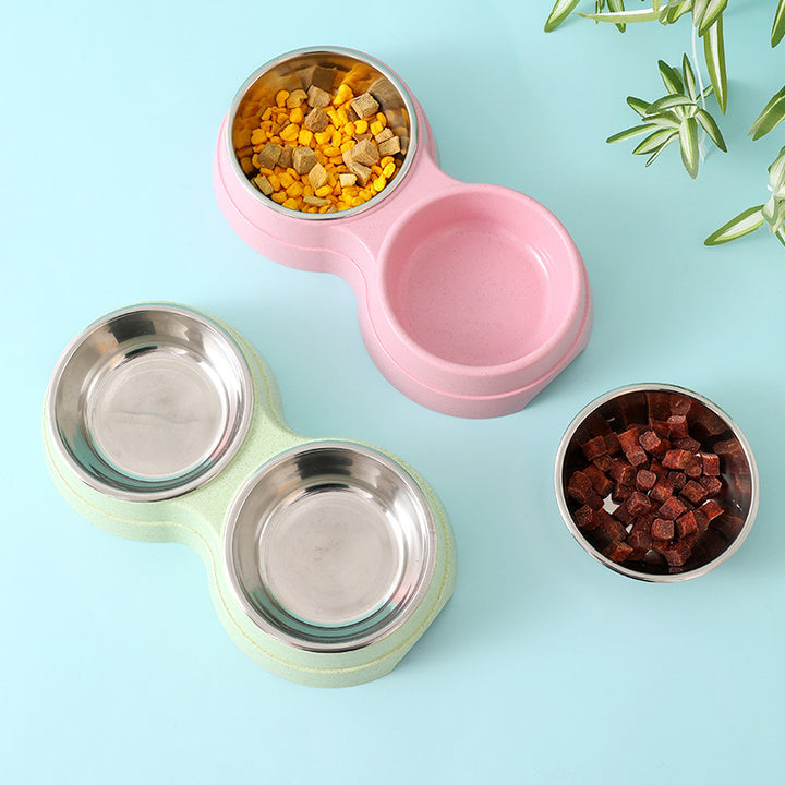 Pink and green pet bowls with food on a light blue background