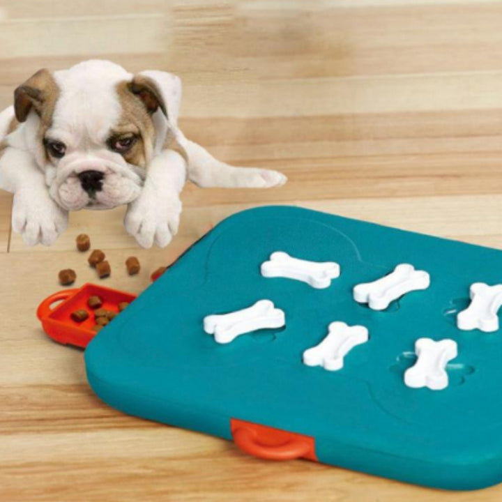 Puppy playing with a blue puzzle toy on a wooden floor.