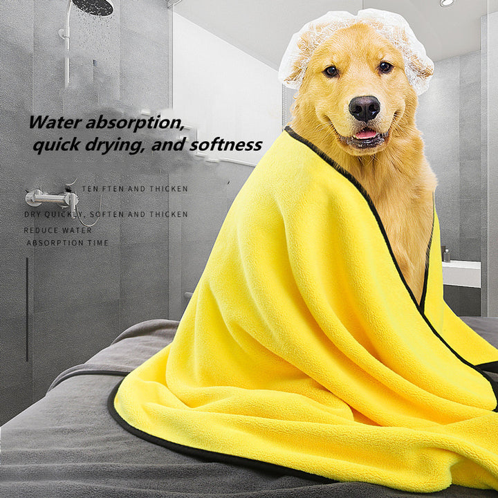 Dog wrapped in a yellow towel in a bathroom setting