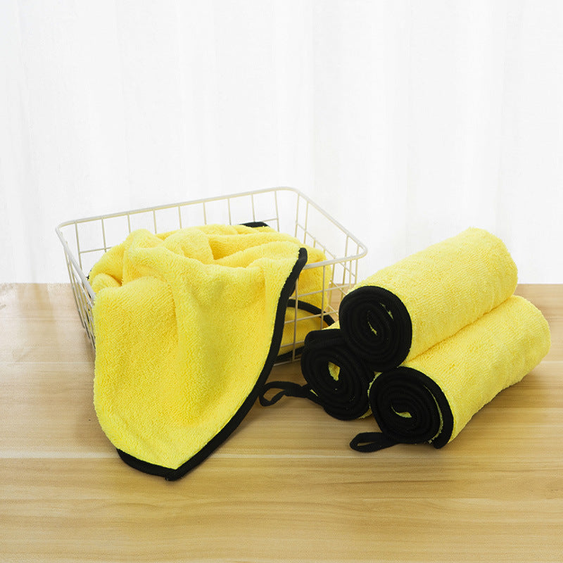 Yellow towels and black loops on a wooden surface with a white background