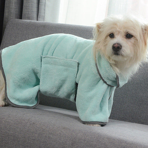 Dog wearing a light green robe on a gray couch