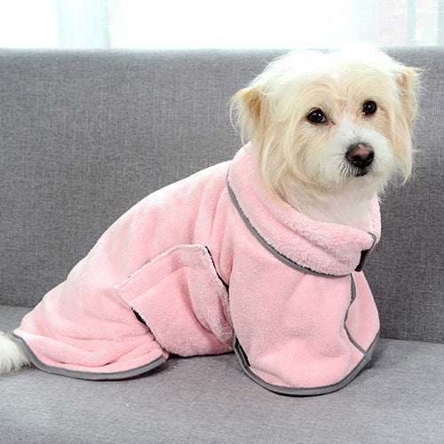 Dog wearing a bathrobe sitting on a gray couch.