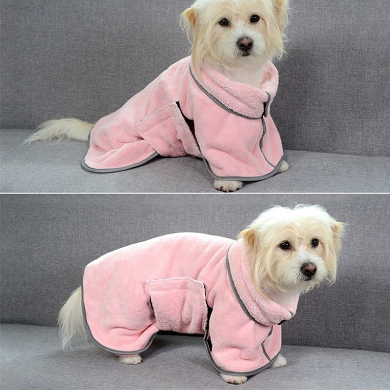 Dog wearing a pink robe sitting on a gray couch.