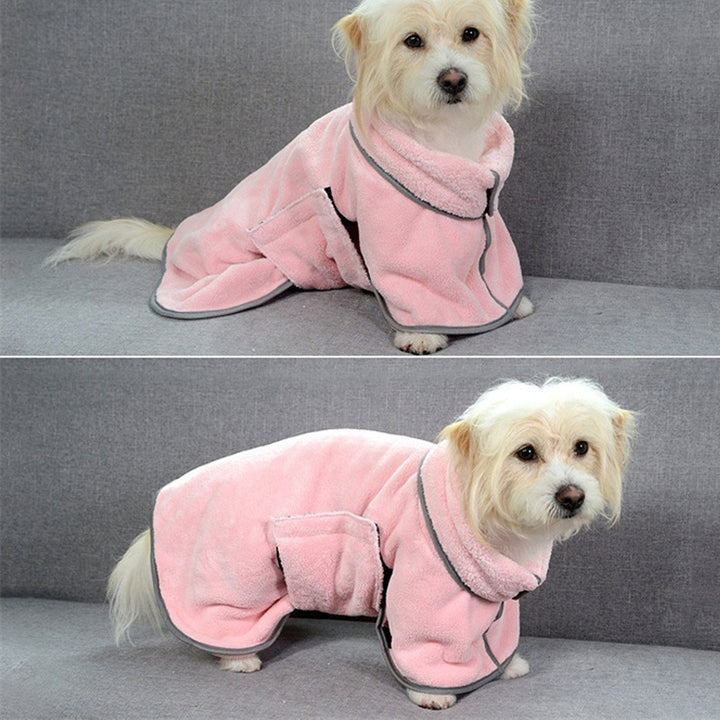 Dog wearing a pink robe sitting on a gray couch.