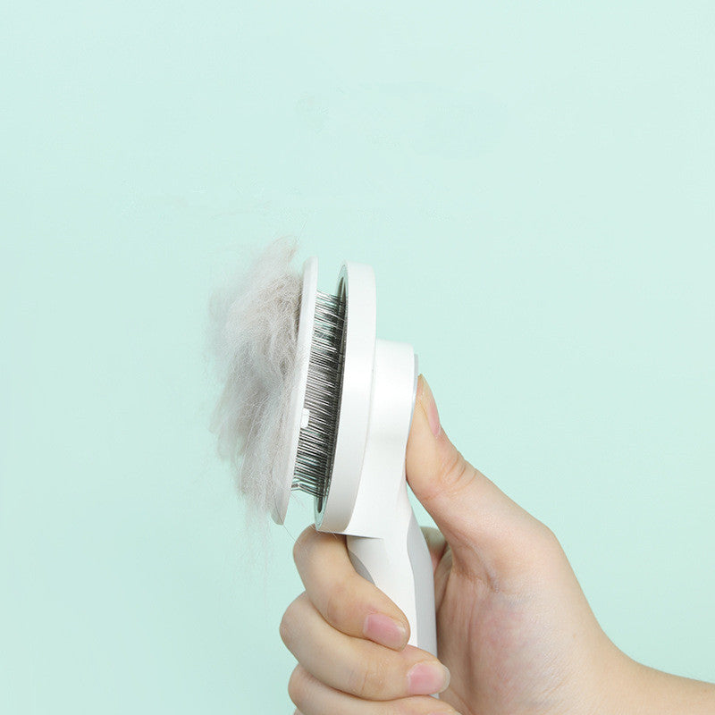 Hand holding a pet grooming brush with collected fur against a light blue background