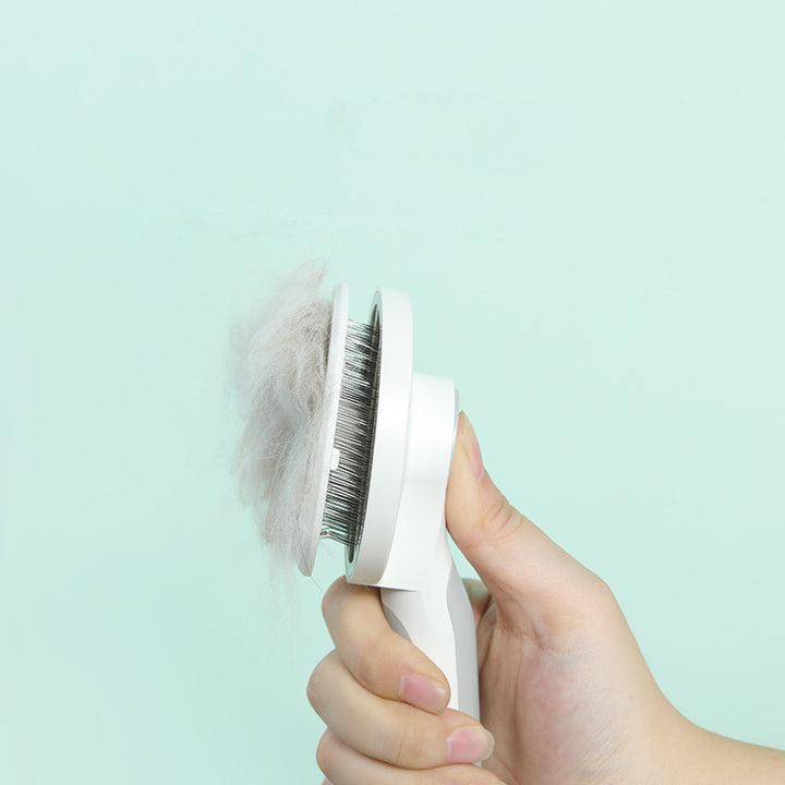 Hand holding a pet grooming brush with collected fur against a light blue background