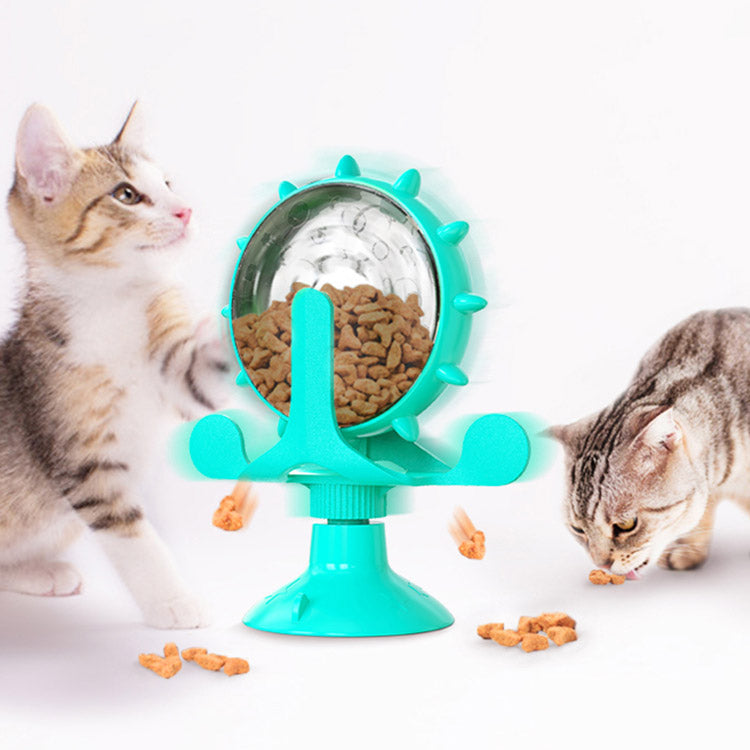Turquoise pet toy with a circular dish containing cat food, with two cats interacting with it.