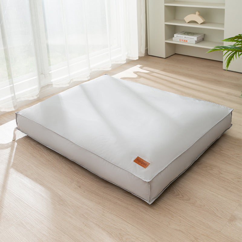 White mattress on a wooden floor with a neutral background