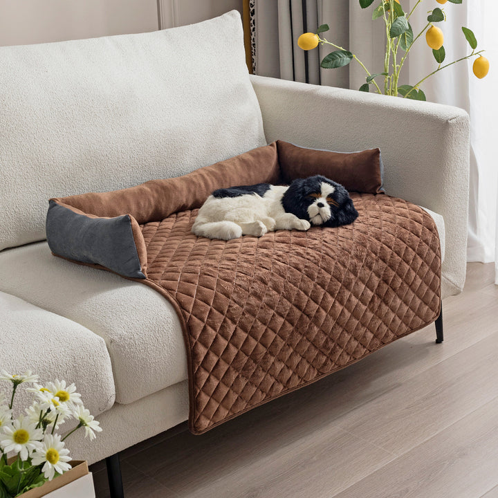 Dog lying on a brown quilted pet bed on a sofa with decorative elements.
