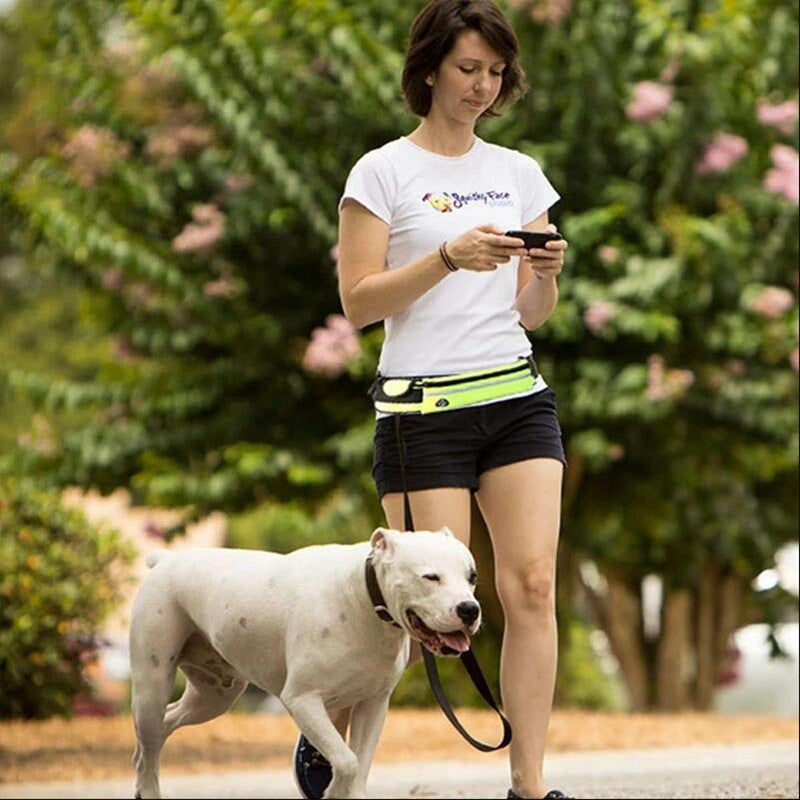 Woman walking a white dog on a leash in a park-like setting