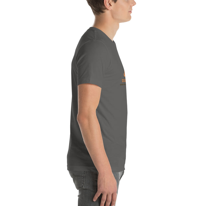 Person wearing a dark gray t-shirt with a logo on a white background