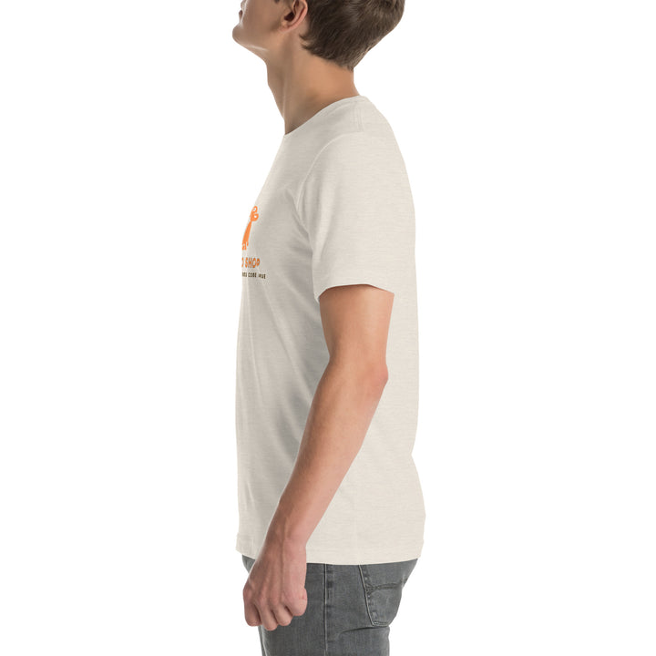 Person wearing a dust colored t-shirt with a logo on a white background