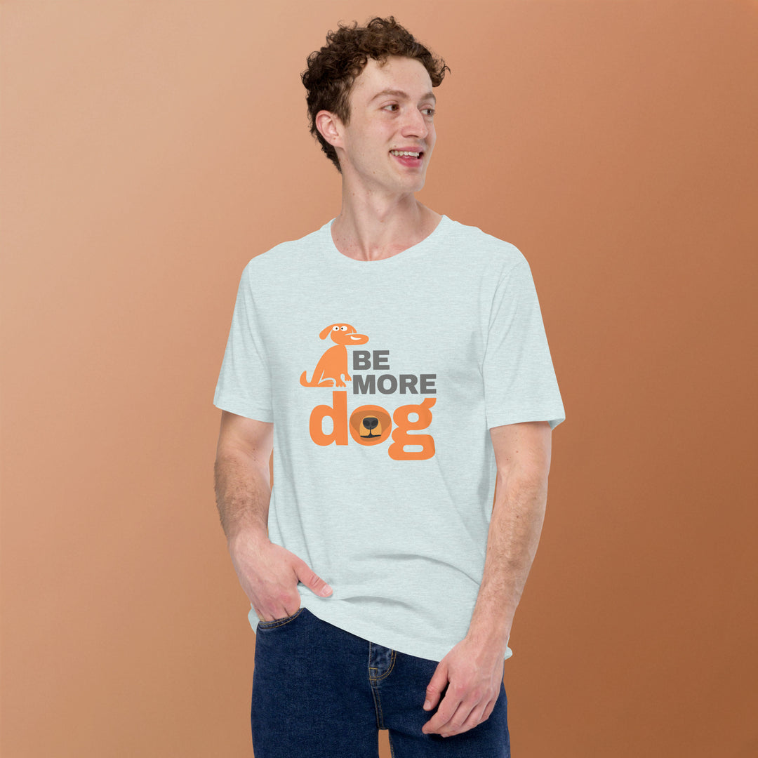 Man wearing a light blue t-shirt with 'Be More Dog' text and graphic on a brown background