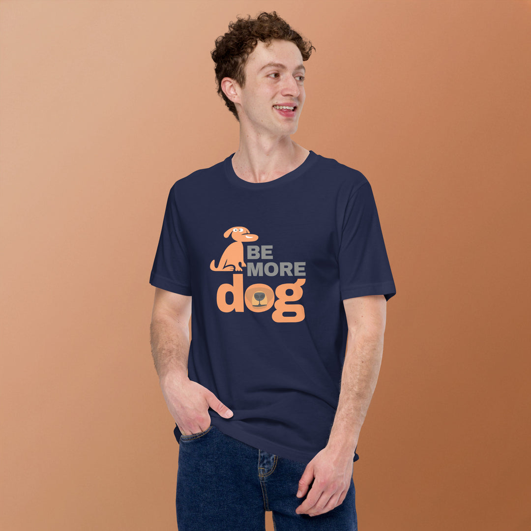 Man wearing a navy blue t-shirt with 'Be More Dog' text and graphic on a brown background