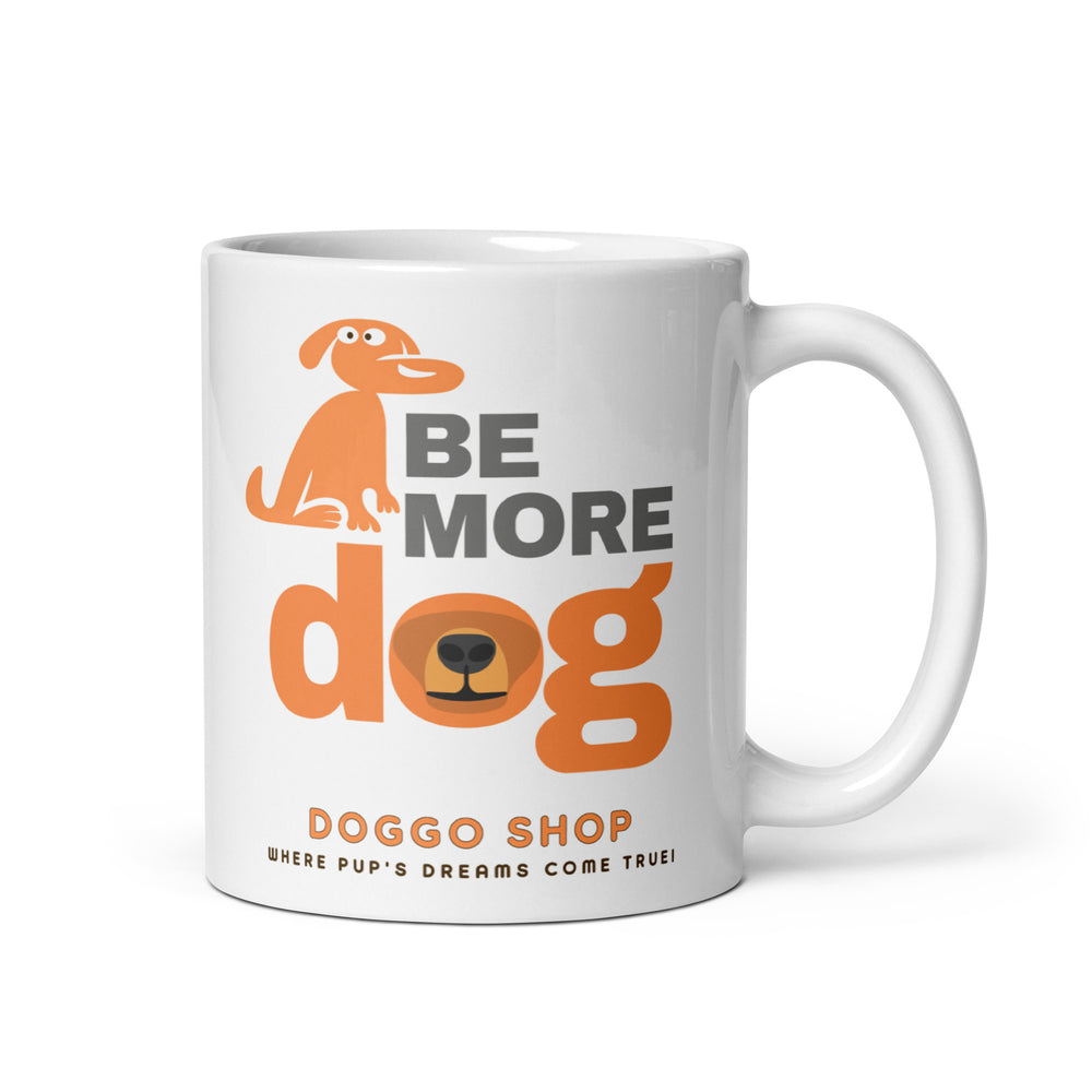 White ceramic glossy mug with 'be more dog print' on a white background